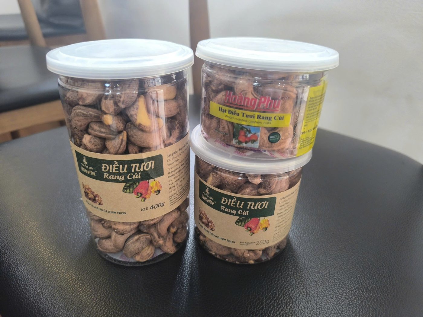 Hũ 400g và hũ 250g hạt điều rang củi để trên bàn